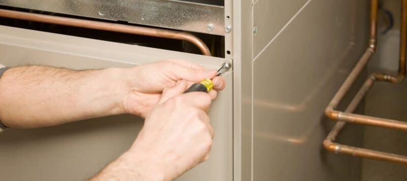 technician repairing furnace in Gilbert's home