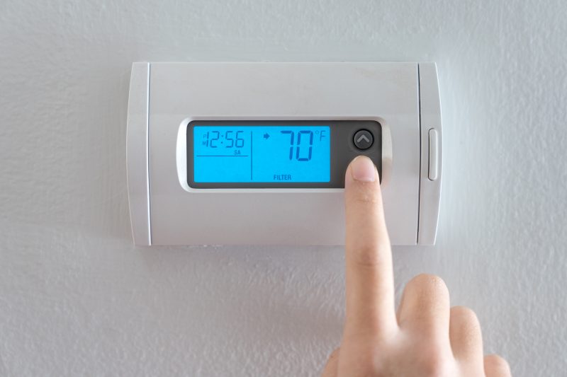 hand setting temperature on thermostat